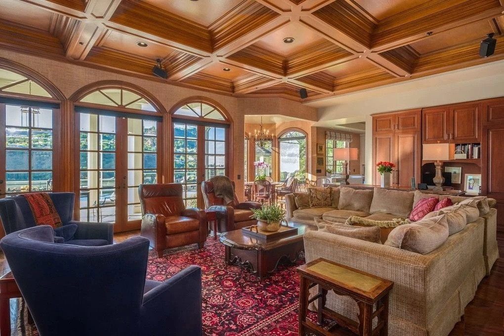 Family room with arched French doors and coffered ceiling in a Mediterranean-style home