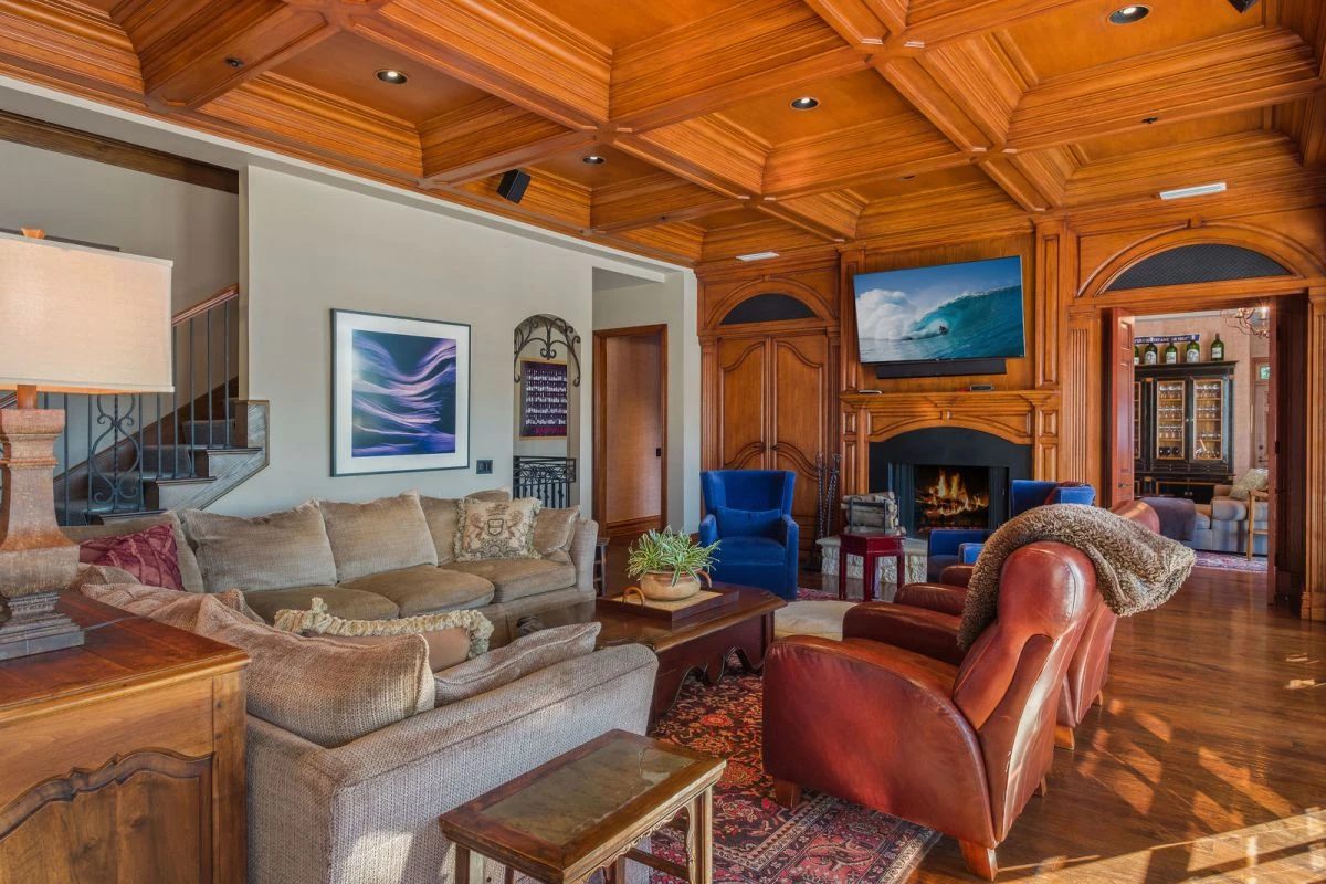 Family room with coffered wood ceiling and wall-mounted TV in a Mediterranean-style home