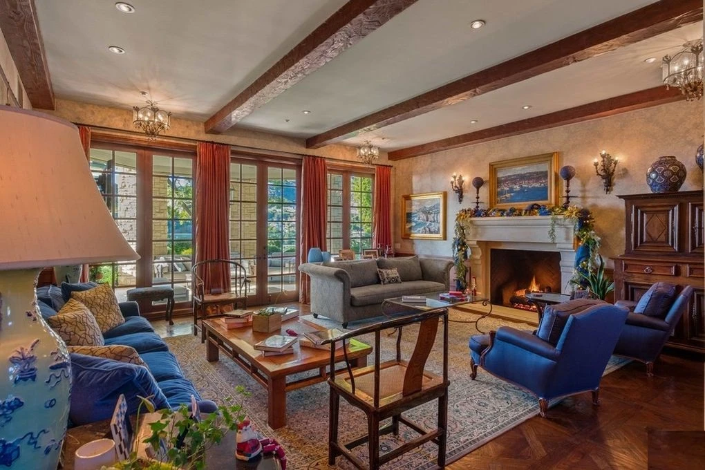 Formal sitting room with carved stone fireplace in a Mediterranean-style home